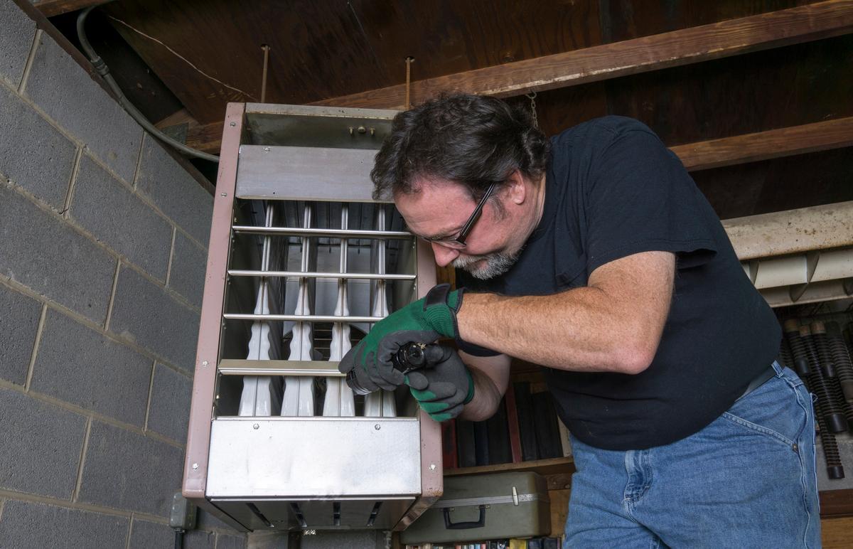 Gas furnace with heat exchanger panel open in attic installation