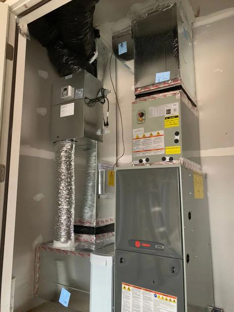 A residential air handler with flexible duct work, installed in a closet.