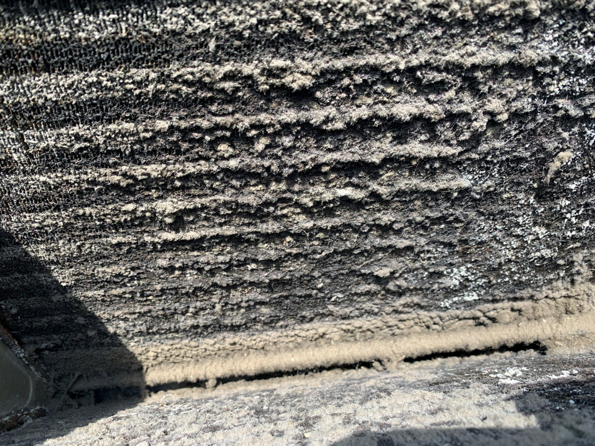 Extreme close-up of dirty evaporator coil core with thick mold and dust matting