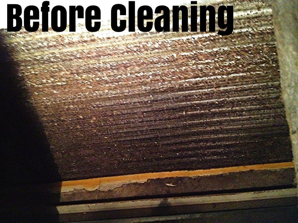 Evaporator coil before cleaning — brown, caked with dust, mold, and debris